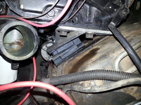 1994 Ford Bronco - This image shows a close-up view of the engine bay of a 1994 Ford Bronco, focusing on the engine mount and surrounding wiring and hoses.