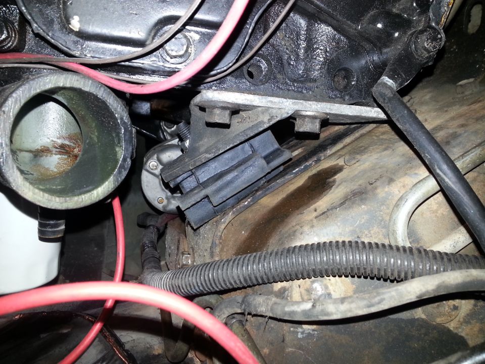 Engine bay of a 1994 Ford Bronco showing engine mount, wiring, and hoses.