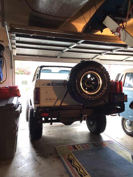 1981 Ford Bronco - The rear view of a white Ford Bronco is shown parked in a garage. It has a spare tire mounted on the back and a license plate reading '1PYC…