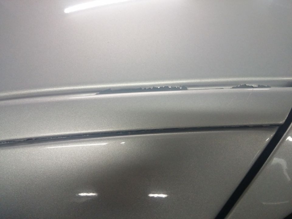 Close-up photo of silver car body trim and panel gap