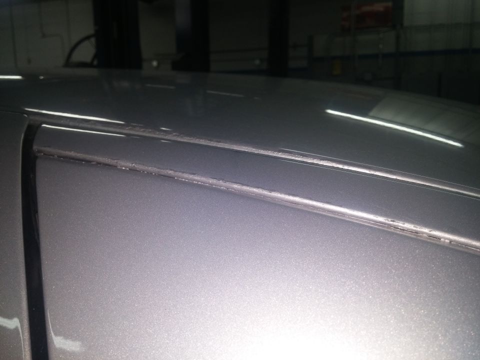 Photo of silver car roof edge and windshield trim