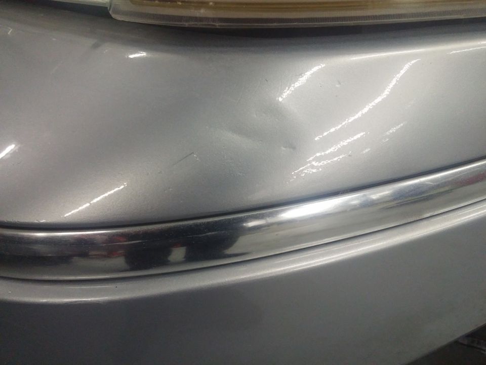 Photo of car front fender, chrome trim and headlight