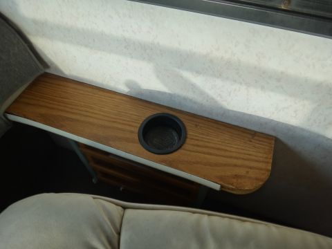 1995 Chevrolet P30 1 Ton - Step Van - A wooden console with a black cup holder is mounted to the interior wall of a vehicle. The console appears to be an add-on modification.