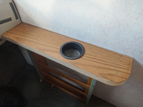 1995 Chevrolet P30 1 Ton - Step Van - A wooden shelf with a built-in cup holder is mounted against a textured wall, likely in a vehicle's interior. The shelf appears to be a cus…