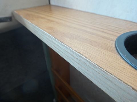 1995 Chevrolet P30 1 Ton - Step Van - This is a close-up shot of a wooden countertop with a dark circular object embedded in it. The countertop has a visible wood grain pattern…