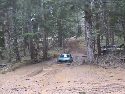 1994 Ford Explorer - Off-roading adventure through a wooded area with muddy terrain and two vehicles.