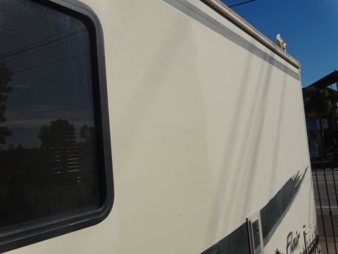 1995 Chevrolet P30 1 Ton - Step Van - A side view of a cream-colored step van shows a dark-tinted window on the left and a dark graphic stripe along the bottom right. The vehicl…