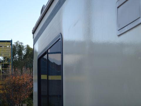1995 Chevrolet P30 1 Ton - Step Van - The side of a step van with a dark-trimmed window and a light-colored exterior. A yellow sign with text is visible to the left.
