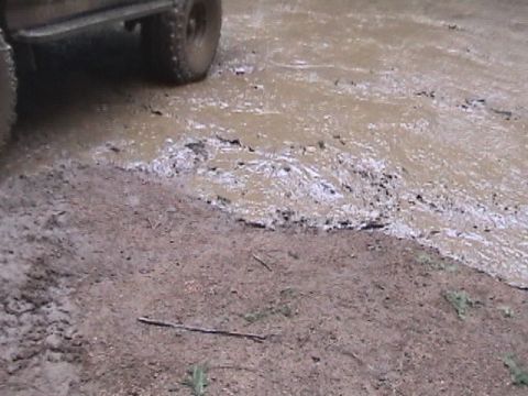 1994 Ford Explorer - A vehicle tire is partially submerged in muddy water.