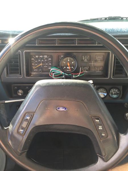 1981 Ford Bronco - The interior of a 1981 Ford Bronco shows the dashboard with a tachometer mounted above the steering wheel. The steering wheel has cruise co…