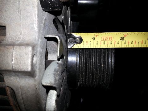 1994 Ford Bronco - A yellow measuring tape is placed against the pulley of an alternator, showing the measurement to be approximately 1 3/4 inches.
