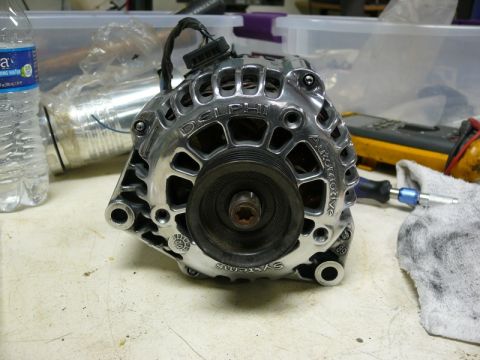 Polished chrome Delphi automotive alternator on a workbench.