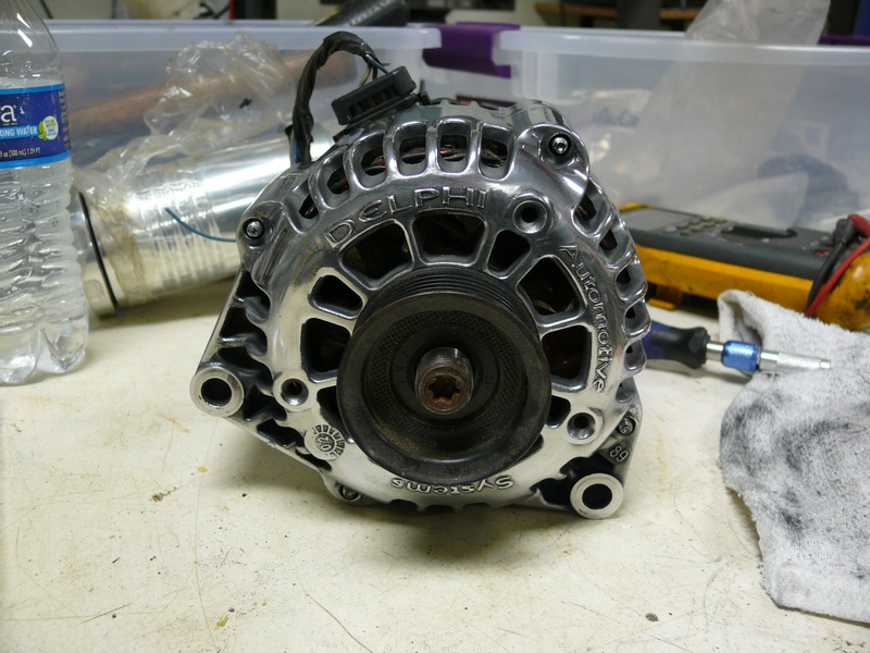 Polished chrome Delphi automotive alternator on a workbench.