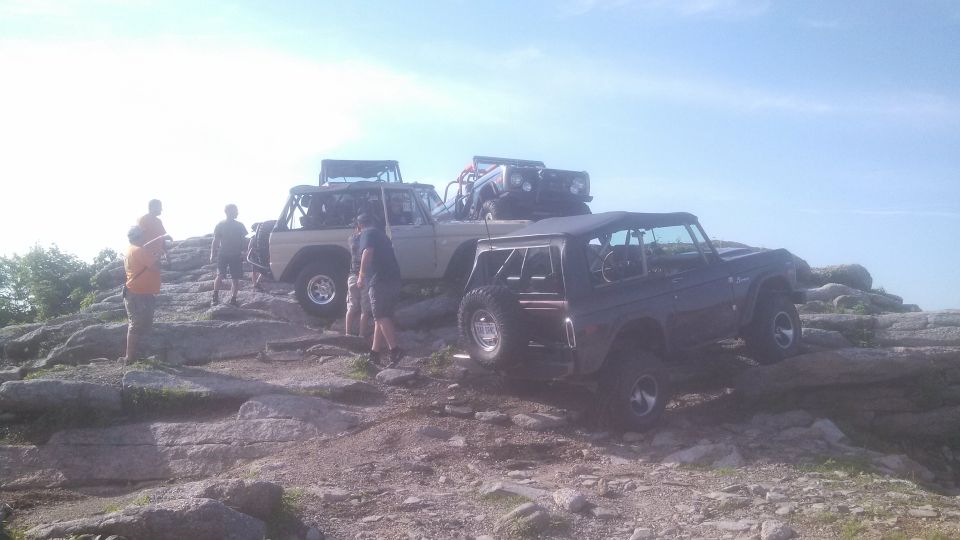 Multiple Ford Broncos parked on a rocky hill.