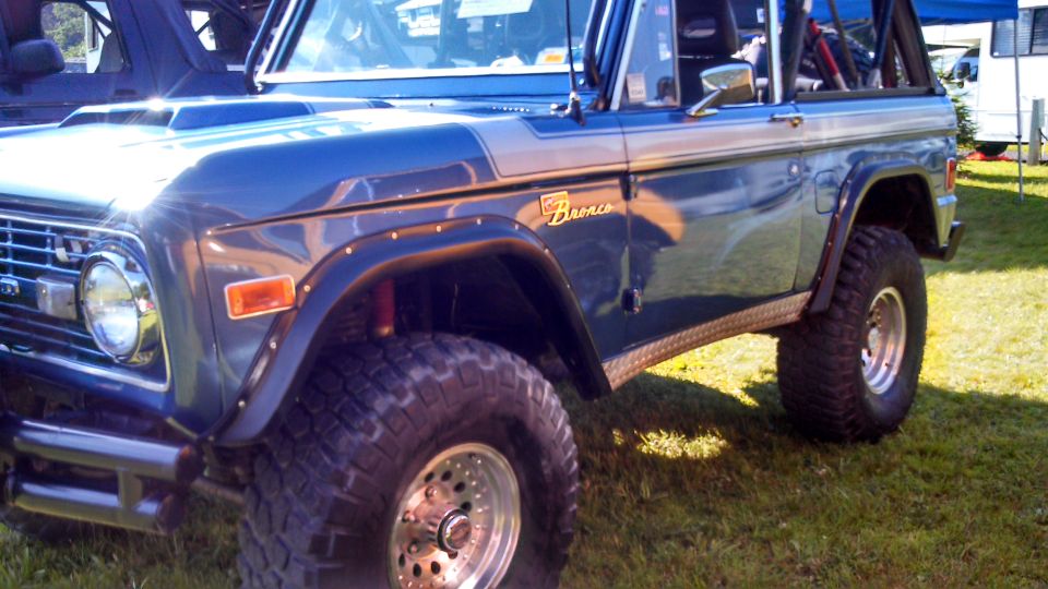 1979 Ford Bronco, right side view, dark blue with silver stripe, off-road tires