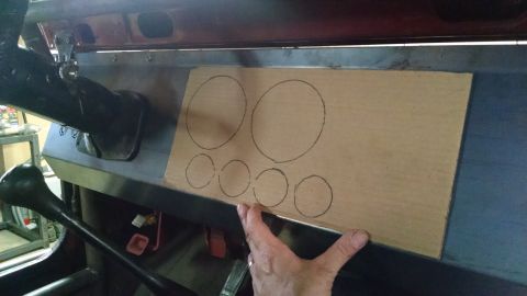 1985 Jeep CJ7 - A hand is holding a piece of cardboard with drawn circles on it, placed on the dashboard of a vehicle. The cardboard appears to be a templa…