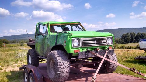 1979 Ford Bronco - A heavily modified, bright green off-road truck with large tires is loaded onto a trailer. The truck has a roll cage and appears to have su…
