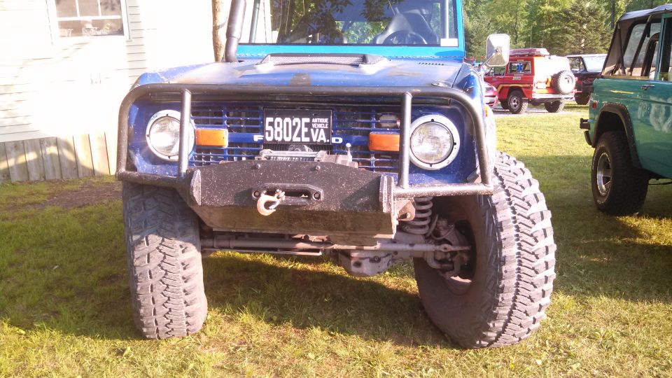 Front view of a blue Ford Bronco with a winch and off-road tires.
