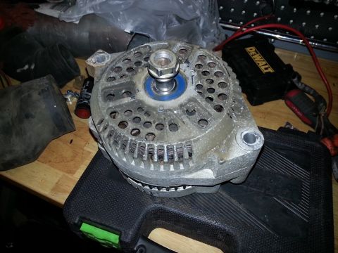1994 Ford Bronco - Close-up of a vehicle alternator, likely removed for repair or replacement.