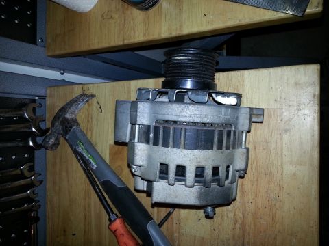 1994 Ford Bronco - An alternator is shown next to a hammer and screwdriver, with the SuperMotors logo in the corner.