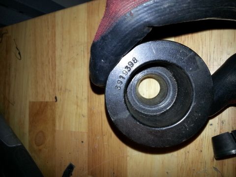 1994 Ford Bronco - A metal part with stamped numbers is held by a gloved hand.