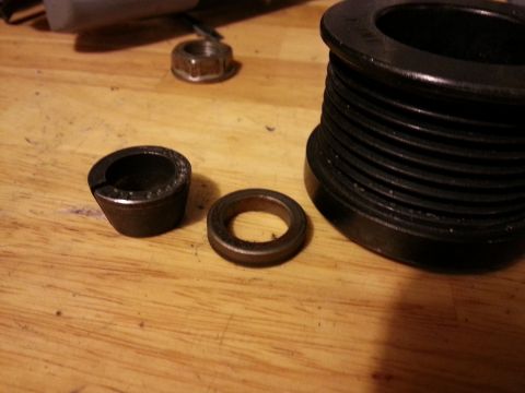 1994 Ford Bronco - Close-up of automotive pulley and bearing components laid out on a wooden surface.