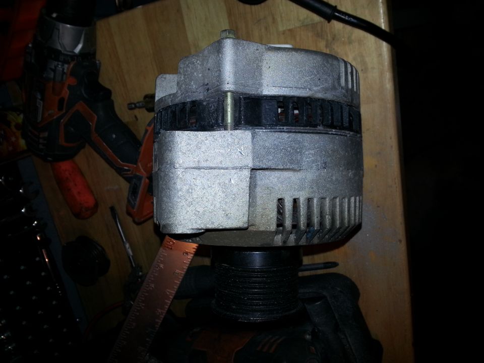 close-up of an alternator with a ruler next to it