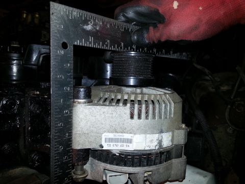 1994 Ford Bronco - Close-up of an alternator being measured with a ruler, revealing its part number.