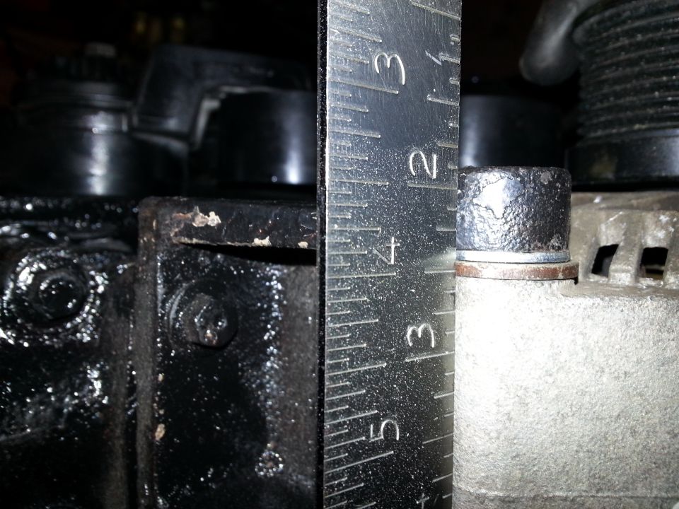 Ruler measuring bolt head on an alternator