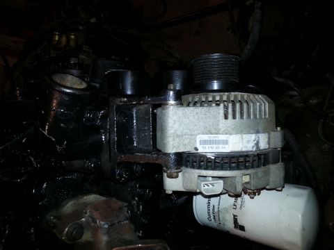 1994 Ford Bronco - Close-up view of an engine's alternator and oil filter, showing part numbers and manufacturer details.