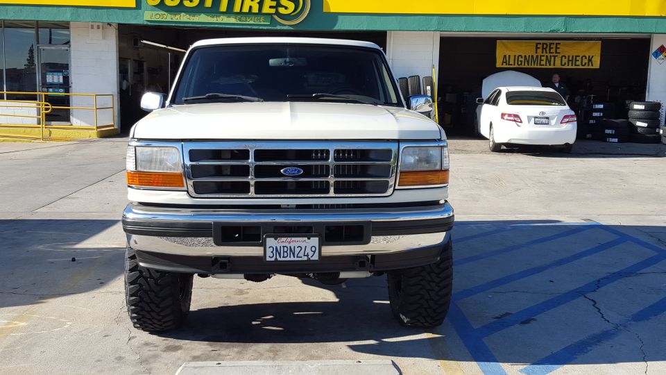 White 1990s Ford Bronco front view with off-road tires and California license plate
