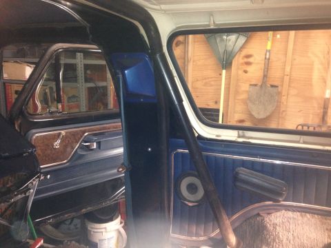 1979 Ford Bronco - Interior view of a vintage vehicle, likely a 1979 Ford Bronco, showing the driver's side door panel, roll cage, and a speaker. The backgrou…