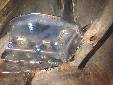 1979 Ford Bronco - A close-up view shows a custom metal reinforcement plate welded into the undercarriage of a vehicle, secured by several blue-nutted bolts.…