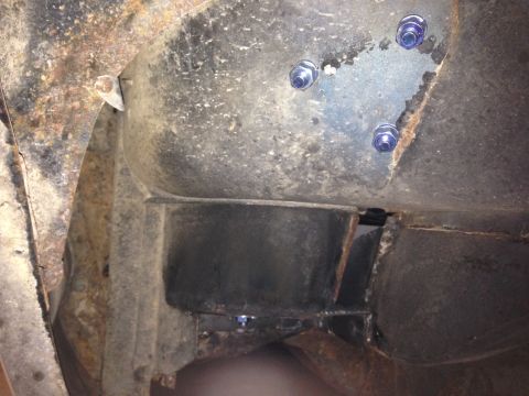 1979 Ford Bronco - This image shows the underside of a vehicle, focusing on the frame and suspension components. Several bolts with blue nuts are visible, sec…