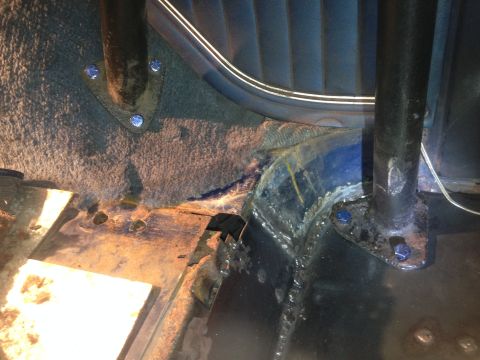 1979 Ford Bronco - This image shows the interior floor area of a vehicle, likely a 1979 Ford Bronco, with exposed metal, carpeted sections, and two black supp…