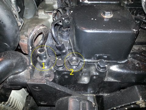 1994 Ford Bronco - Two yellow circles highlight fittings on a black engine component. Circle 1 points to a small, ribbed fitting with a black cap. Circle 2 po…