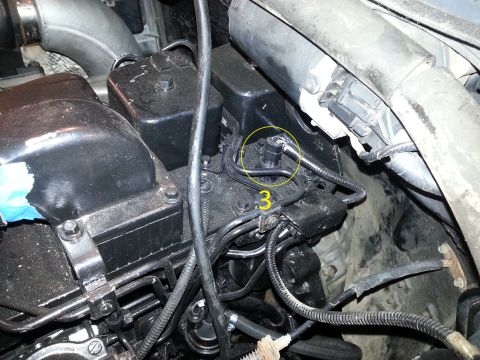1994 Ford Bronco - A close-up view of the engine bay of a 1994 Ford Bronco, focusing on the fuel injection system. The yellow circle highlights a specific com…