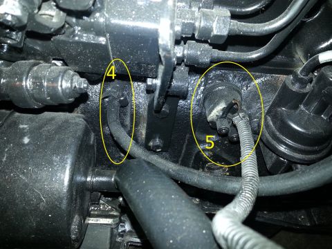 1994 Ford Bronco - A close-up view of engine components, with two sensors circled and labeled with numbers 4 and 5. The engine bay appears dirty and oily.