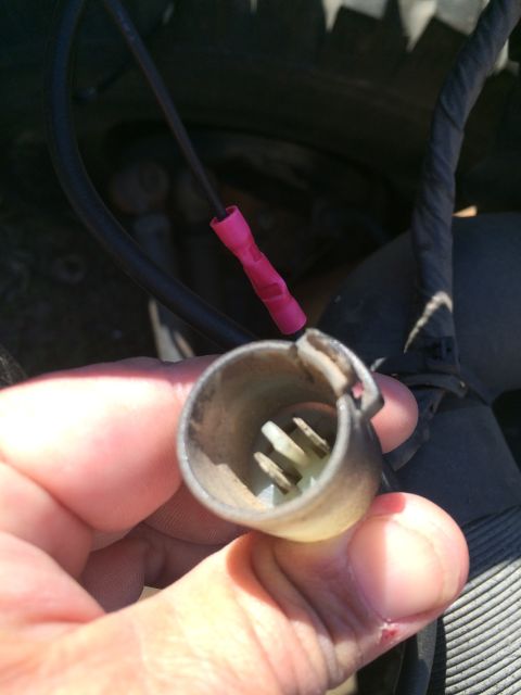 1987 Suzuki Samurai - Photograph of a hand holding a corroded light bulb socket, not a technical document.