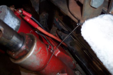 1973 Ford F-250 - A close-up view shows red painted hydraulic cylinder with two red insulated electrical connectors attached to wires. A white fluffy materia…
