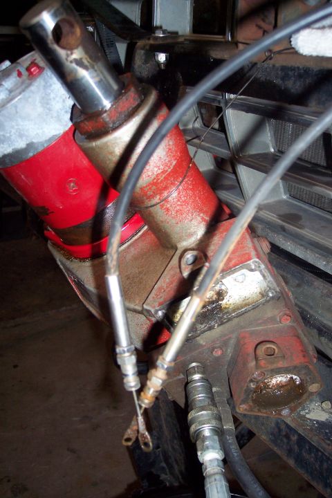 1973 Ford F-250 - A close-up view of a hydraulic steering unit on a vehicle, likely a truck, showing hydraulic lines and connectors. The unit is red and silv…