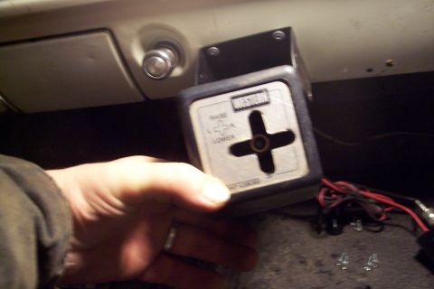 1973 Ford F-250 - A hand holds a Western snowplow controller with a directional joystick and labels for raise, lower, left, and right. The controller is moun…