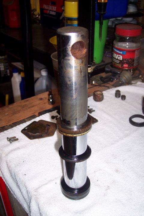 1973 Ford F-250 - A disassembled metal cylinder with a hole drilled through the top rests on a white towel. Various metal parts and a jar of coffee are visib…