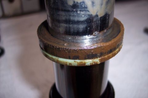 1973 Ford F-250 - A close-up view of a dirty, metallic component, possibly a part of a vehicle's suspension or drivetrain, showing significant grime and some…