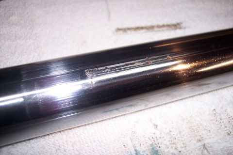 1973 Ford F-250 - A close-up shot shows a chrome-plated cylindrical part with visible rust and scratches along its surface. The part is resting on a white cl…
