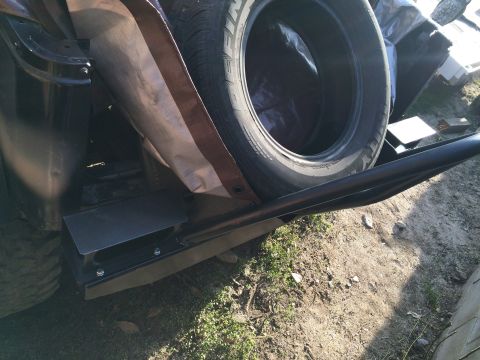 1987 Suzuki Samurai - Photograph of a fabricated rock slider and spare tire, not a technical document.