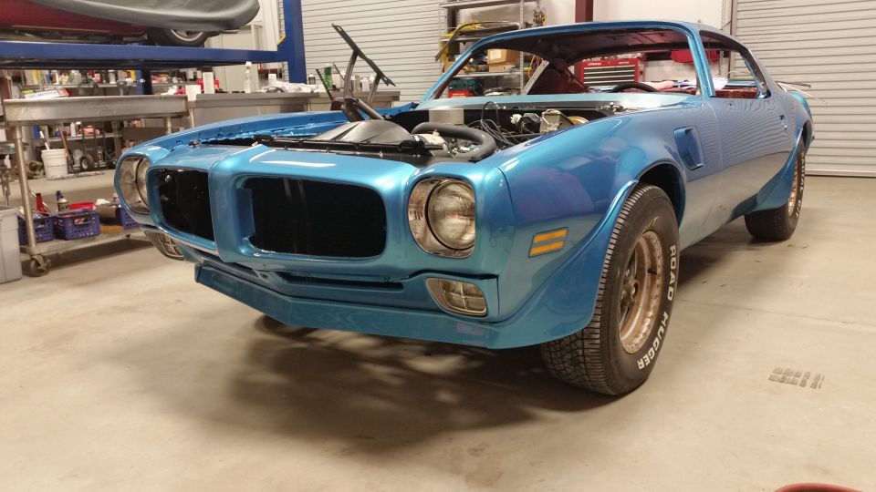 1970 Pontiac Trans Am in a garage with hood open, blue exterior