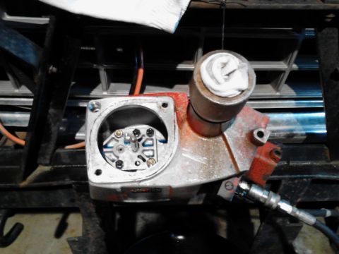 1973 Ford F-250 - A close-up view of a hydraulic pump assembly, likely from a vehicle, showing internal components and a connected hose.