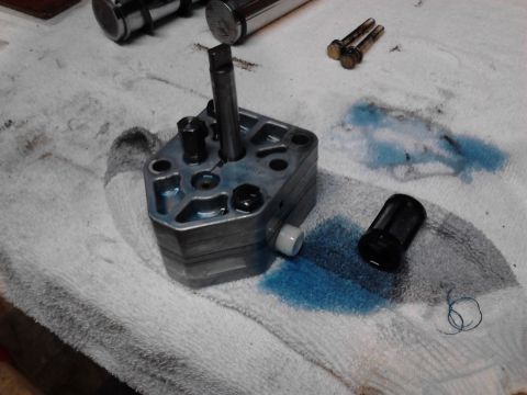 1973 Ford F-250 - A disassembled fuel pump assembly is laid out on a white towel with blue fluid stains. Several bolts and a small filter are also visible.