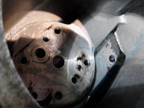 1973 Ford F-250 - A close-up view of a metal component with multiple circular holes, some filled with dark liquid. The component appears to be part of an eng…